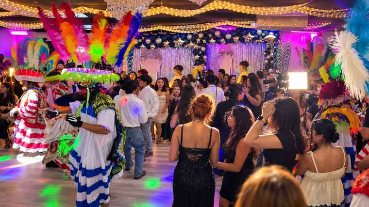 Colorful chinelos dancing with guests in the ballroom