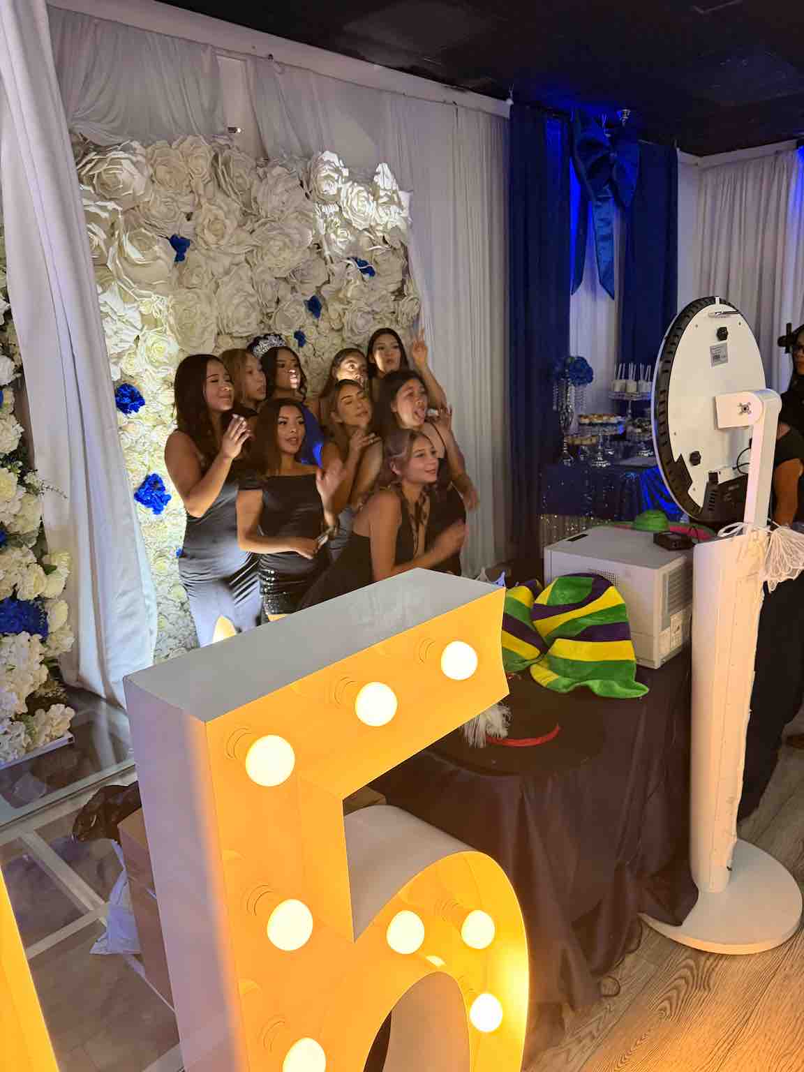 Young guests posing at the photo booth beside an illuminated number 15