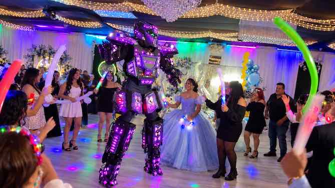 LED robot dancing with the quinceañera and guests
